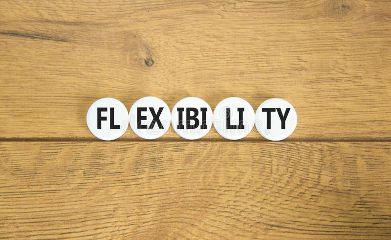 Flexibilitetssymbol. konceptordflexibilitet för vackra vita piller. vacker bakgrund av trä. flexibilitetsbegrepp för företag. royaltyfria foton