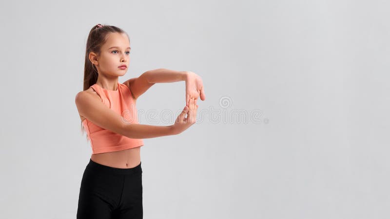 Everyone in life needs balance. Flexible cute little girl child looking aside while stretching her hands isolated on a