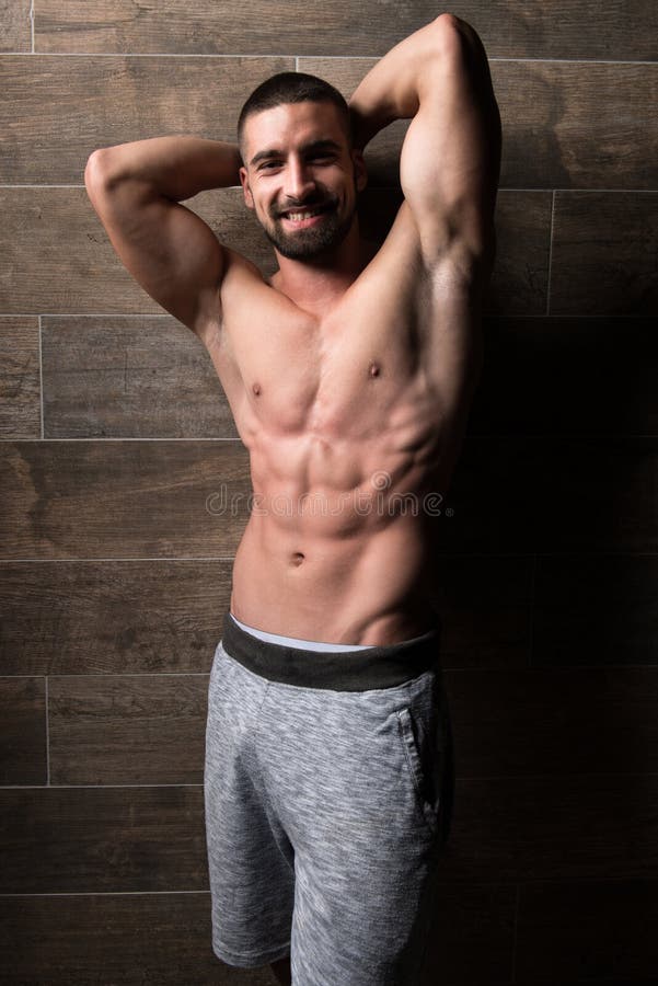 Flexing Muscles Near modelo a parede fotos de stock