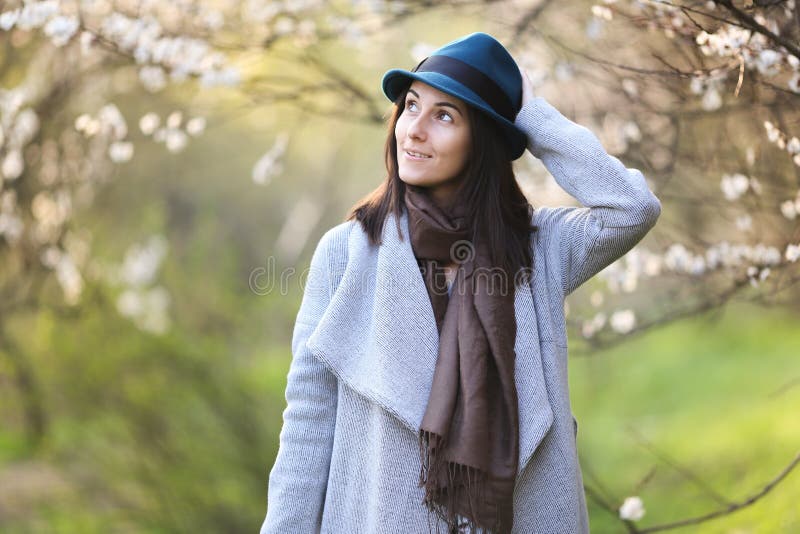 Flicka i en grön hatt i en blommande trädgård royaltyfria foton