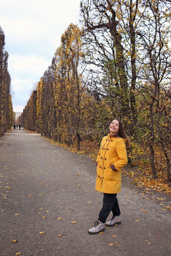 Flicka i gula rocken på parkhösten royaltyfria bilder