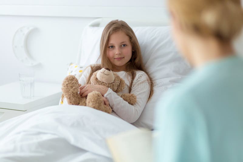 Flicka i sjukhuset som rymmer en nallebjörn arkivfoton Flicka i sjukhuset som rymmer en nallebjörn arkivfoton