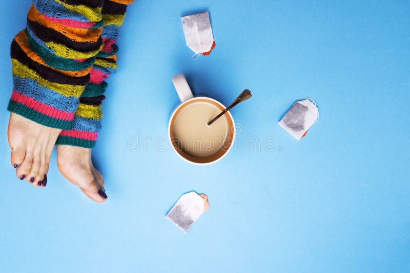 Girl in socks and surrounded by coffee and tea. The concept of stopping for coffee breaks. Drinks. Girl in socks and surrounded by coffee and tea. The concept of stopping for coffee breaks. Drinks.