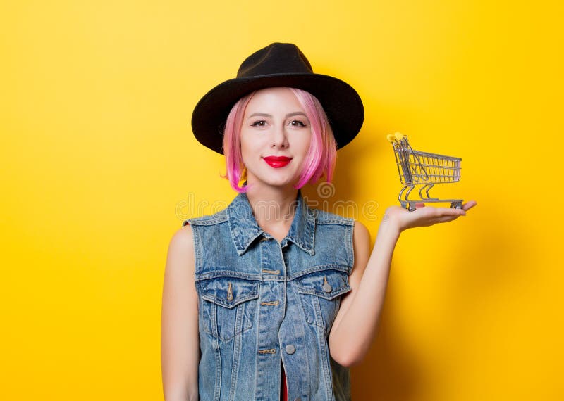 Flicka med den rosa frisyren med shoppingvagnen arkivfoto Flicka med den rosa frisyren med shoppingvagnen arkivfoto