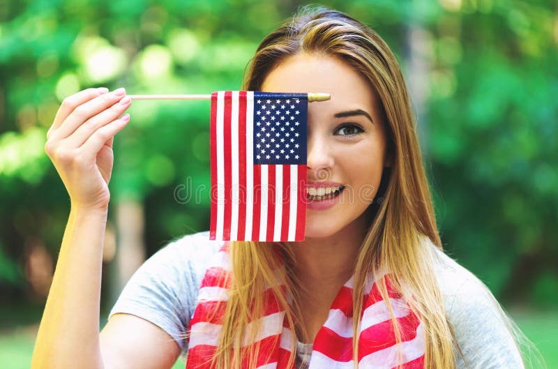 GIrl with an American flag on the fourth of July in her backyard. GIrl with an American flag on the fourth of July in her backyard