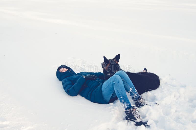 Flicka med en hund på kusten av en vintersjö arkivfoton Flicka med en hund på kusten av en vintersjö arkivfoton