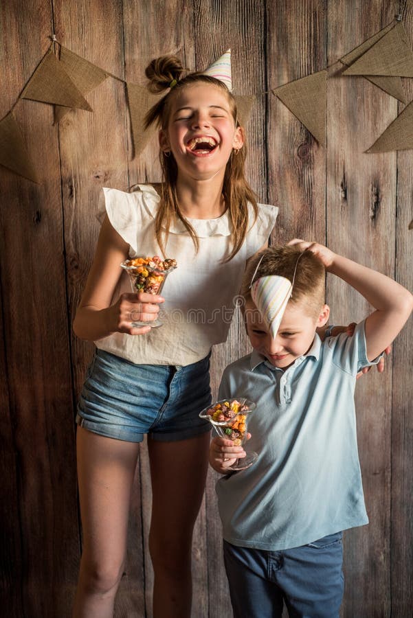 Flicka pojke som delar äta popcorn i en bunke på en trätabellbakgrund Dela begrepp royaltyfri fotografi Flicka pojke som delar äta popcorn i en bunke på en trätabellbakgrund Dela begrepp royaltyfri fotografi