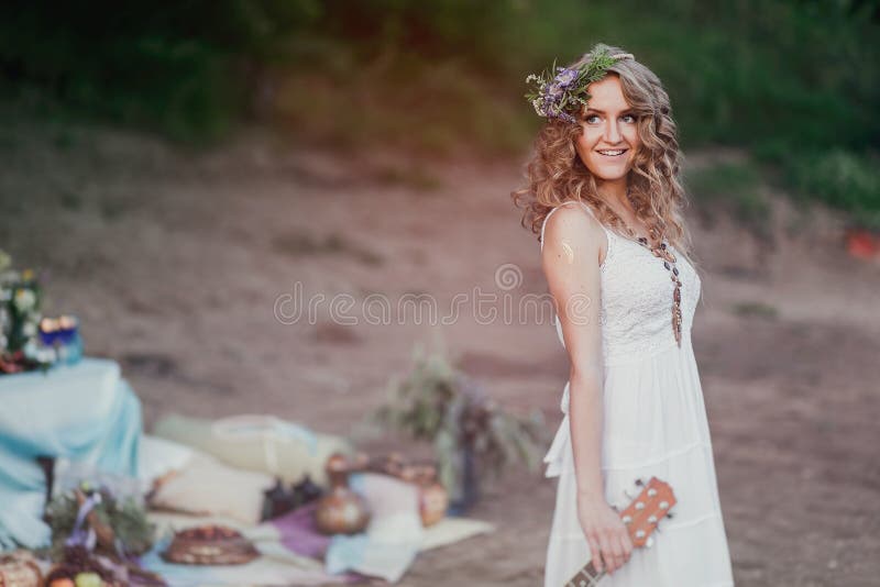 Flicka på en sommarpicknick i sundress och en krans av lösa blommor med kopieringsutrymme royaltyfria bilder Flicka på en sommarpicknick i sundress och en krans av lösa blommor med kopieringsutrymme royaltyfria bilder