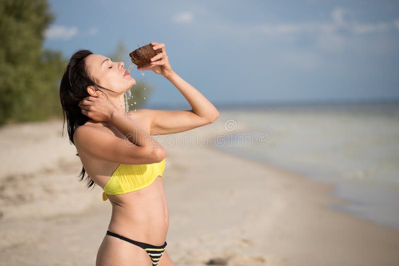 Flicka på stranden med kokosnöten arkivfoto Flicka på stranden med kokosnöten arkivfoto