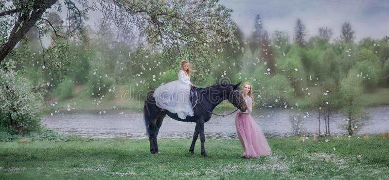 Flicka på svart häst i blomningträdgård royaltyfri bild Flicka på svart häst i blomningträdgård royaltyfri bild
