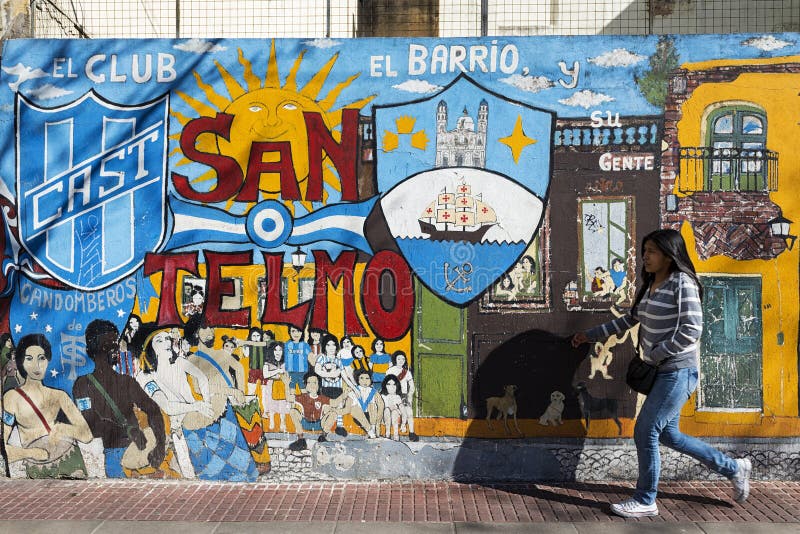 Flicka som framme passerar av en väggmålning i den San Telmo grannskapen, Buenos Aires, Argentina arkivbilder Flicka som framme passerar av en väggmålning i den San Telmo grannskapen, Buenos Aires, Argentina arkivbilder
