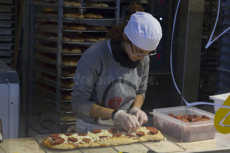 Flicka som förbereder en pizza royaltyfri bild Flicka som förbereder en pizza royaltyfri bild
