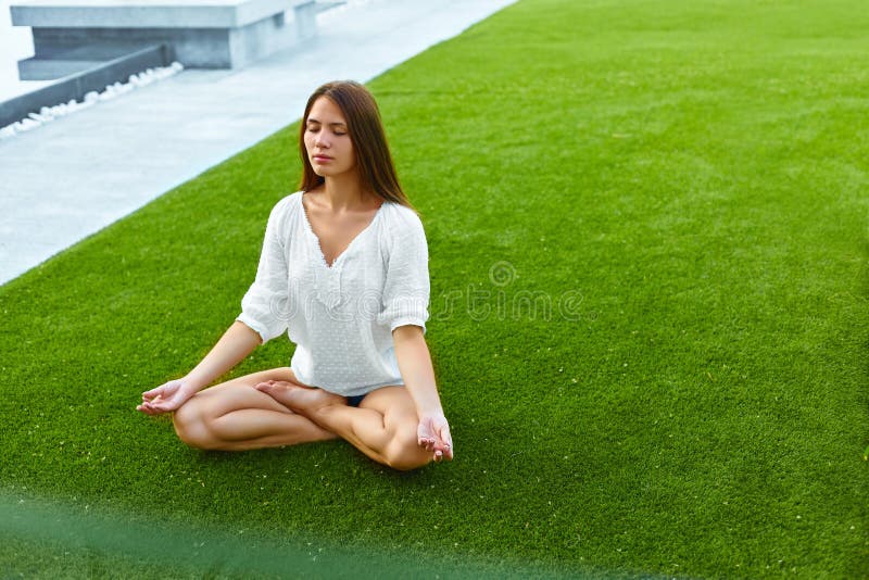 Flicka som mediterar i lotusblommaställing yoga fotografering för bildbyråer Flicka som mediterar i lotusblommaställing yoga fotografering för bildbyråer