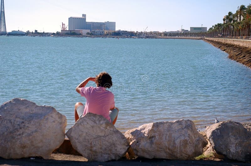 Flicka som ser horisonten på stranden av kusten av fjärden av Cadiz, Andalusia spain arkivbilder Flicka som ser horisonten på stranden av kusten av fjärden av Cadiz, Andalusia spain arkivbilder
