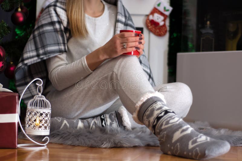 Flicka som sitter på päls- matta i hem- kläder och julsockor royaltyfria bilder Flicka som sitter på päls- matta i hem- kläder och julsockor royaltyfria bilder