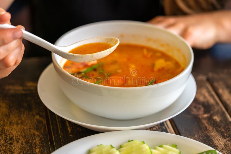 Flicka som äter Tom Yam Kung, thailändsk kokkonst close upp royaltyfria foton Flicka som äter Tom Yam Kung, thailändsk kokkonst close upp royaltyfria foton