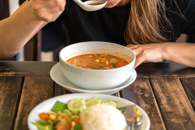 Flicka som äter Tom Yam Kung, thailändsk kokkonst close upp royaltyfria foton Flicka som äter Tom Yam Kung, thailändsk kokkonst close upp royaltyfria foton