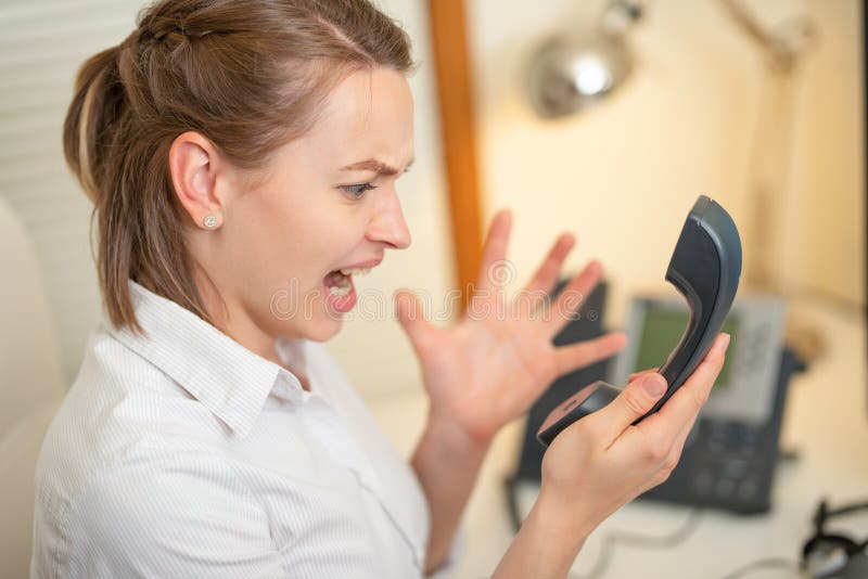 Flickadispatcherrop som arbetar med telefonen I appellmitten som är ilsken ondska royaltyfri bild Flickadispatcherrop som arbetar med telefonen I appellmitten som är ilsken ondska royaltyfri bild