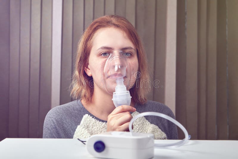 Flickan andas med kompressornebulisersystemet arkivbilder Flickan andas med kompressornebulisersystemet arkivbilder