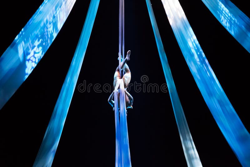 Flickan flyger med flyg- silke i en cirkusetapp på den Devian showen Nusa Dua, Bali, Indonesien royaltyfri bild Flickan flyger med flyg- silke i en cirkusetapp på den Devian showen Nusa Dua, Bali, Indonesien royaltyfri bild