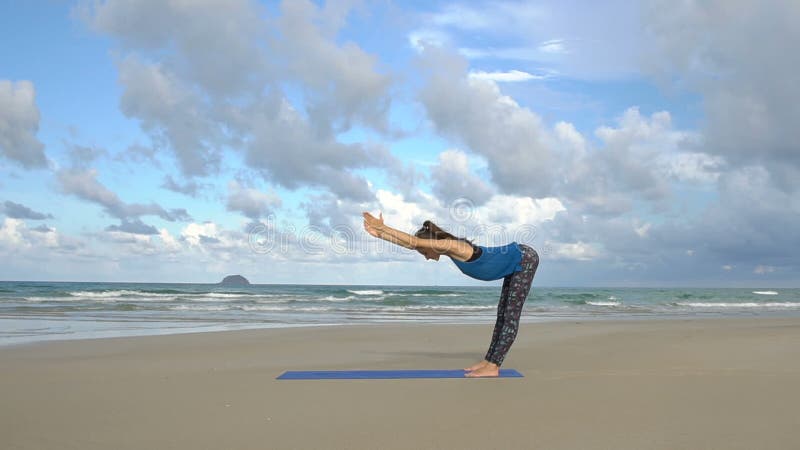 Flickan gör yoga poserar på stranden i Vietnam Lycklig kvinnaavkoppling för hav eller för hav Övningar lugn och harmoni