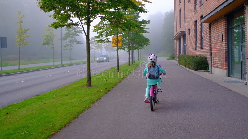 Flickan rider cykeln till skolan