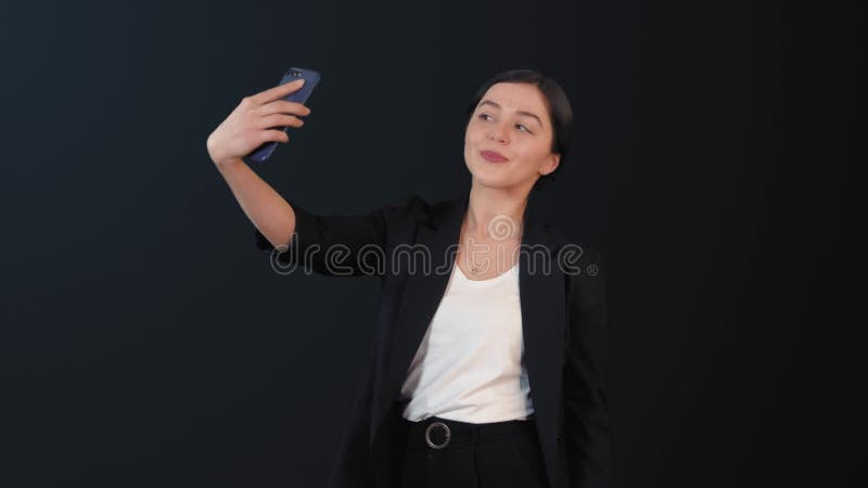 Flickan tar bilder av sig själv på telefonen.