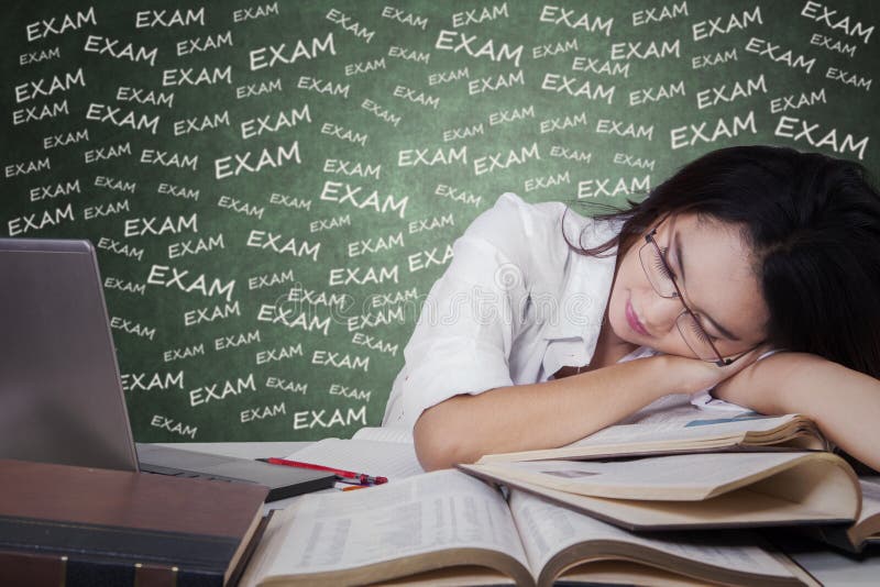 Flickan tar en vila, når han har studerat för examen arkivfoton Flickan tar en vila, når han har studerat för examen arkivfoton