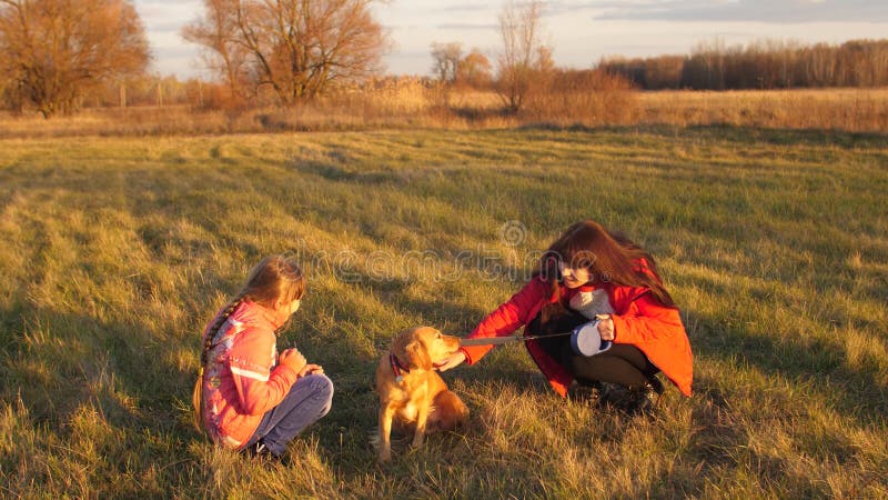 Flickatonåring och mamma som tillsammans slår hunden och att skratta