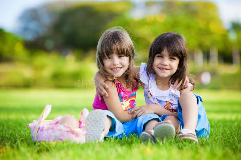 Flickor gräs att krama le två barn