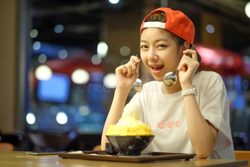 flickor äter Bingsu mangoost - koreansk efterrätt royaltyfria bilder flickor äter Bingsu mangoost - koreansk efterrätt royaltyfria bilder