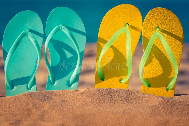 Two pair flip-flops on the sand. Summer vacation concept. Two pair flip-flops on the sand. Summer vacation concept