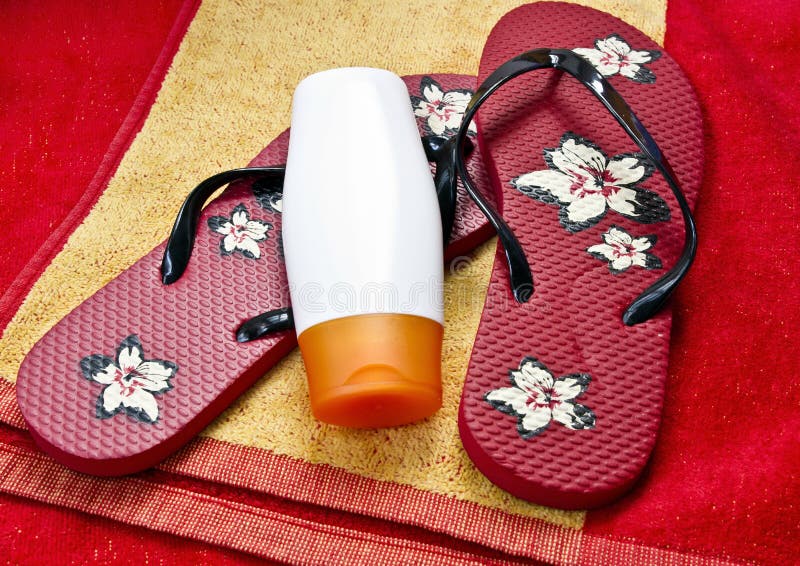 Flipflop and sunscreen on a beach towel