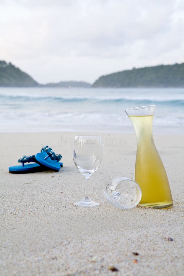 Turquoise flip flops and a carafe of wine on the beach. Turquoise flip flops and a carafe of wine on the beach