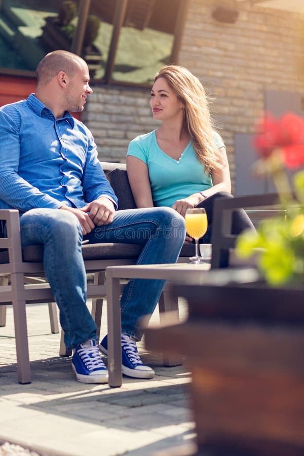 Flirting in a cafe. Beautiful loving couple sitting in a cafe enjoying in coffee and conversation. Love, romance, dating royalty free stock image Flirting in a cafe. Beautiful loving couple sitting in a cafe enjoying in coffee and conversation. Love, romance, dating royalty free stock image