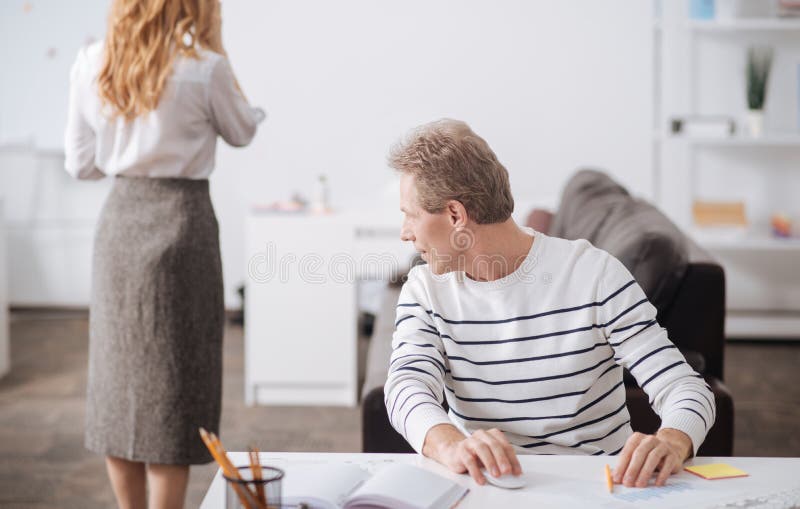 Flirting Mature Worker Looking At Young Woman Body At Work Stock Image Flirting Mature Worker Looking At Young Woman Body At Work Stock Image