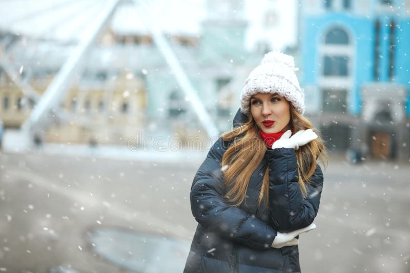 Flirty blond lady walking at the city with snowflakes stock photography