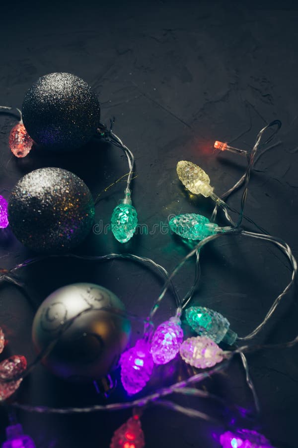 Flitter und helle Girlande, Weihnachtsdekoration auf dunkelgrauem vergipstem Hintergrund lizenzfreies stockbild Flitter und helle Girlande, Weihnachtsdekoration auf dunkelgrauem vergipstem Hintergrund lizenzfreies stockbild