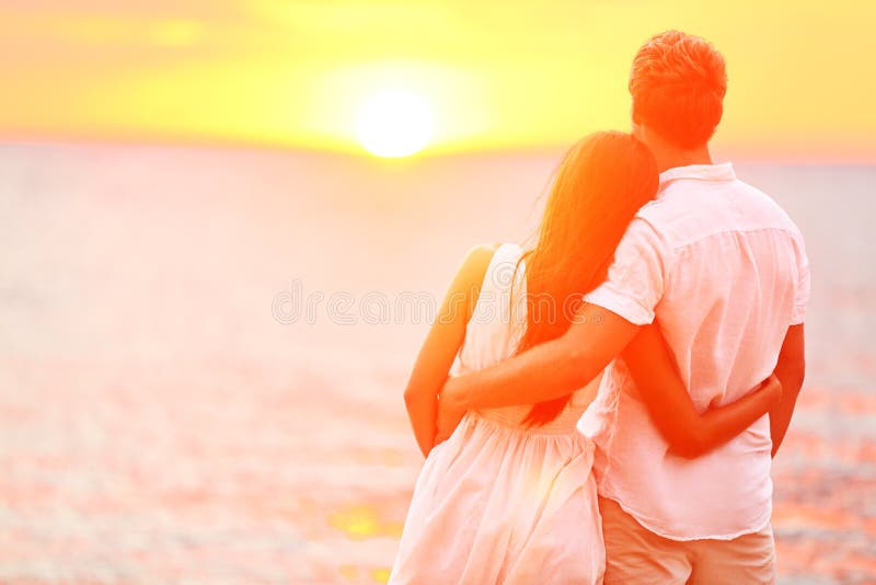 Flitterwochenpaare romantisch in der Liebe bei Strandsonnenuntergang
