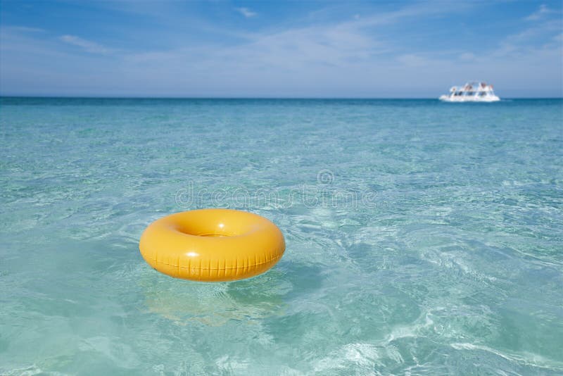 Floating ring on blue clear sea with white boat