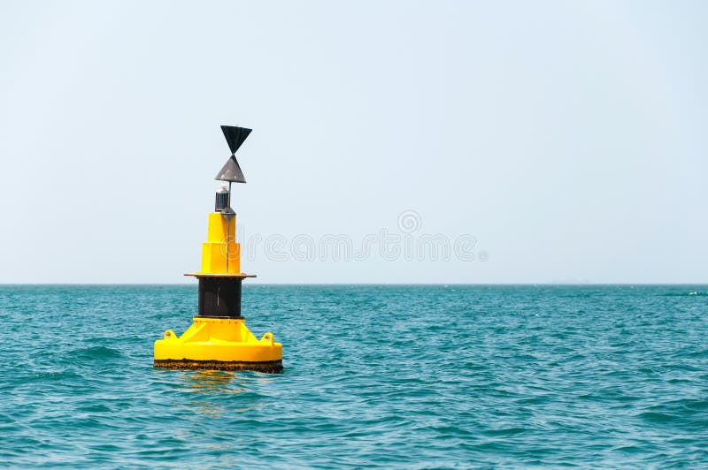 Floating yellow buoy on blue sea