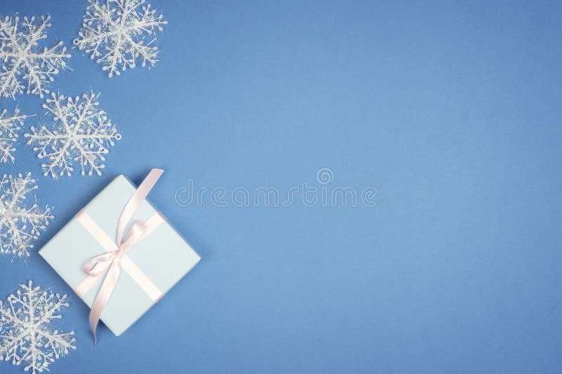 Floco de neve branco decorativo e caixa de presente do ano novo no fundo azul Configuração do plano do Natal fotografia de stock Floco de neve branco decorativo e caixa de presente do ano novo no fundo azul Configuração do plano do Natal fotografia de stock