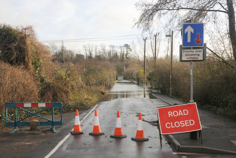 Flooded country road. A country road is closed as a swollen river breaks its banks. Hampshire, England UK stock image Flooded country road. A country road is closed as a swollen river breaks its banks. Hampshire, England UK stock image