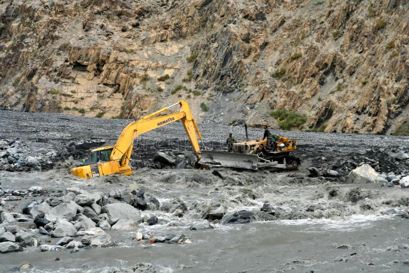 Excavator flooded during attempt at clearing Karakorum Highway from a landslide that caused artificial lake Northern Pakistan. Track hoe construction excavator stock images, royalty-free photos and pictures