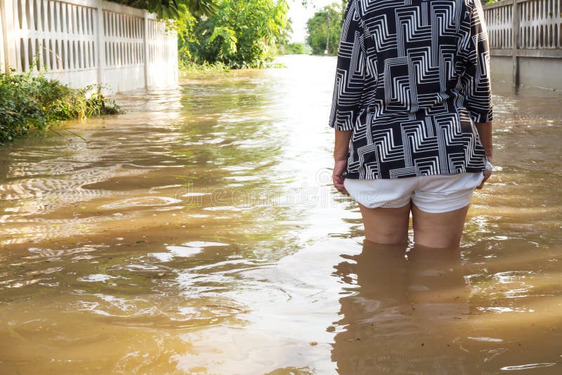 Flooding брода женщины в ее доме Крупный план на ее ноге Behin взгляда стоковое фото Flooding брода женщины в ее доме Крупный план на ее ноге Behin взгляда стоковое фото
