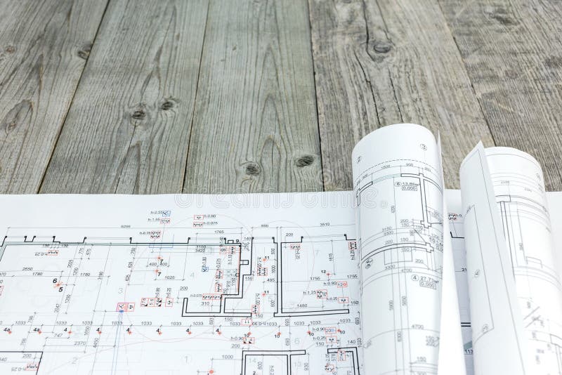 Floor Plan With Rolls Of Architectural Blueprints On Wooden Desk Stock