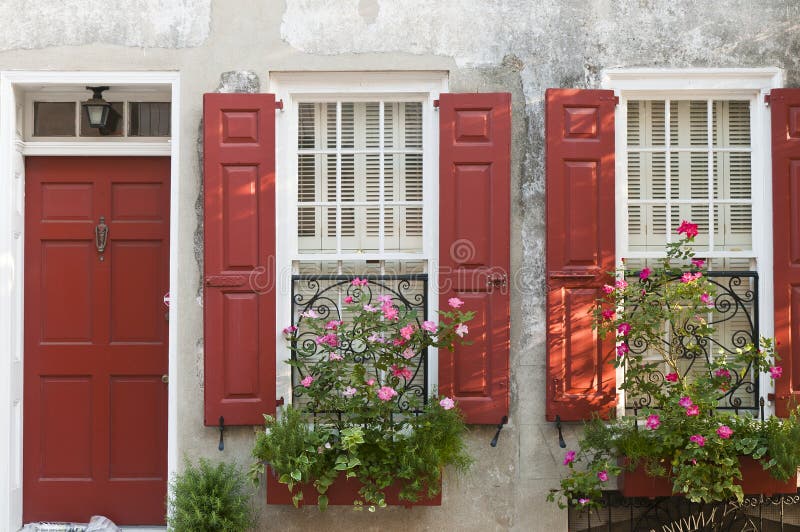 House with red shutters and decorative flower boxes at the windows. House with red shutters and decorative flower boxes at the windows.