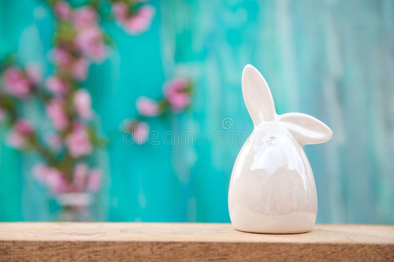 Floral background for text and a white porcelain bunny. Wooden table top with flowers close-up and copy space. Easter rabbit on a royalty free stock images Floral background for text and a white porcelain bunny. Wooden table top with flowers close-up and copy space. Easter rabbit on a royalty free stock images