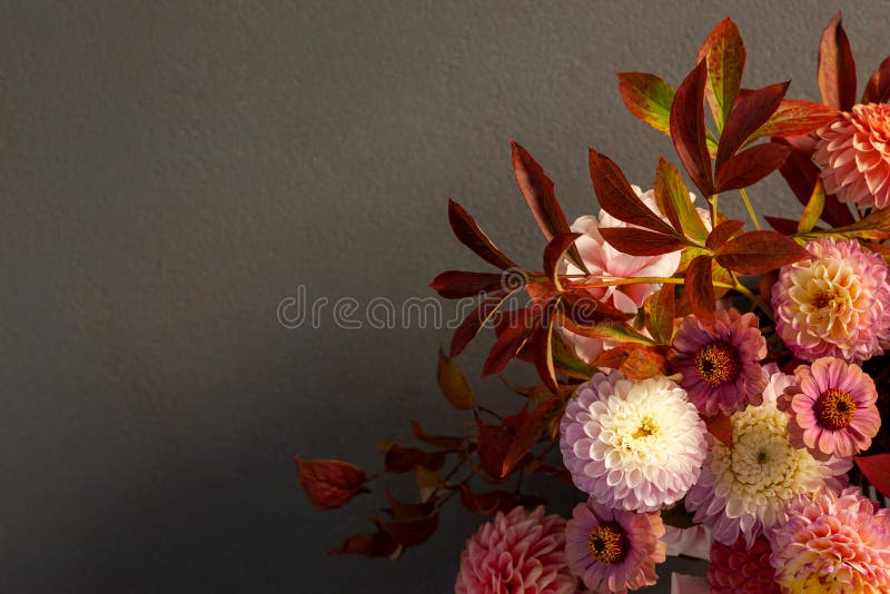 Floral composition of dahlia flowers, roses and autumn leaves.