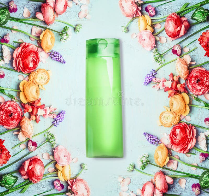 Floral natural cosmetic product and beauty concept. Green Bottle with and flowers on shabby chic background. Top view royalty free stock photos Floral natural cosmetic product and beauty concept. Green Bottle with and flowers on shabby chic background. Top view royalty free stock photos